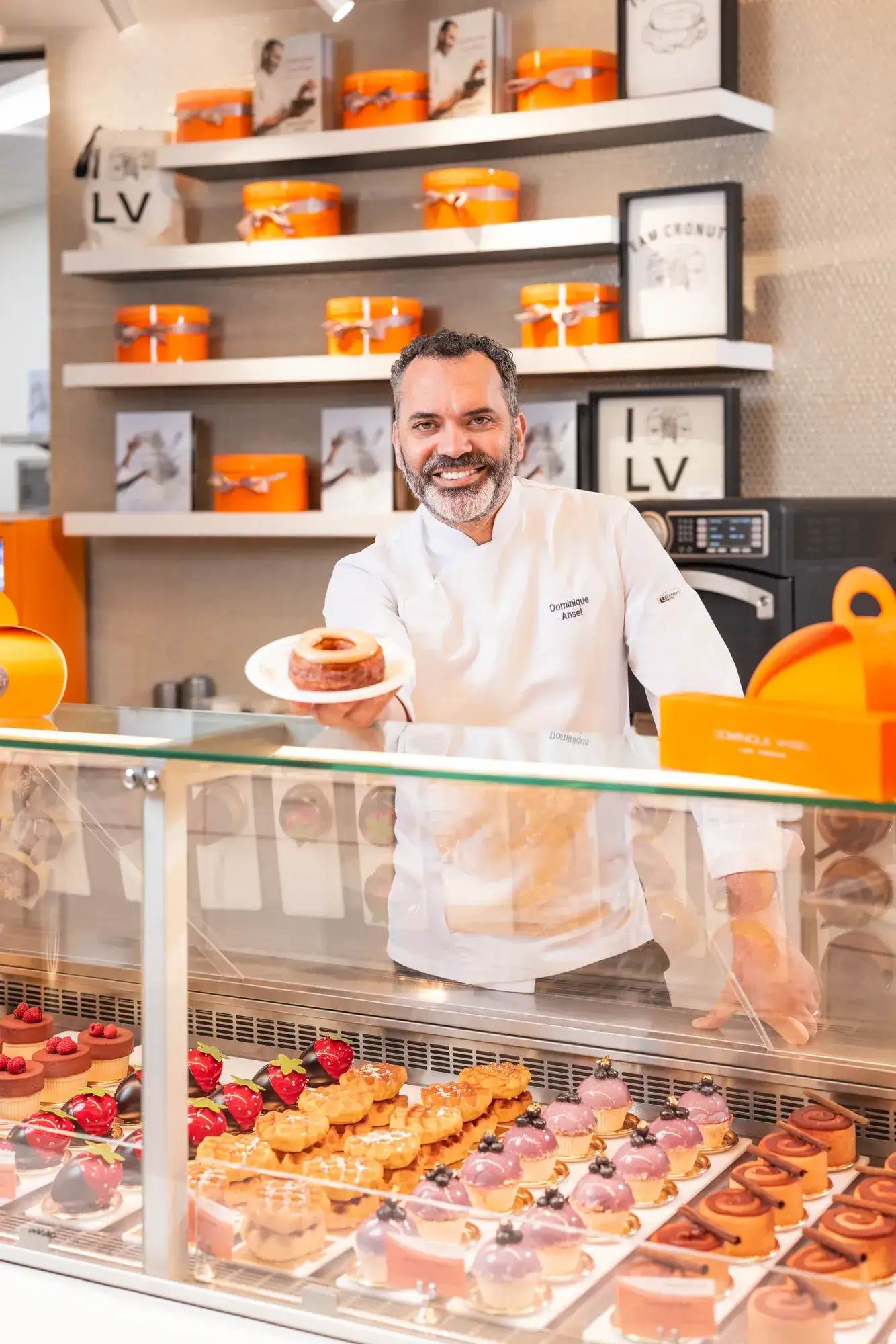 Dominique Ansel posing in front of baked goods