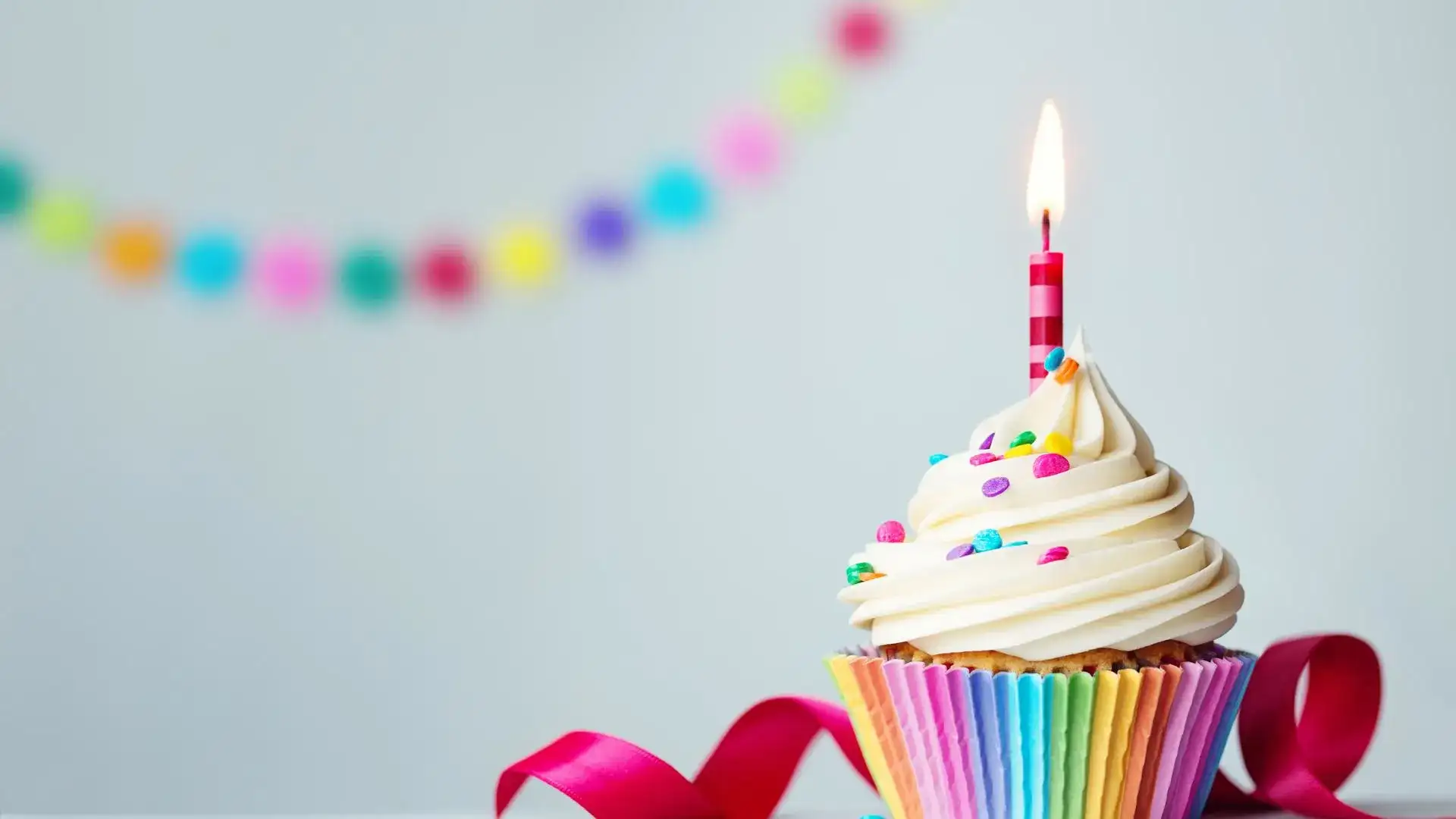 Rainbow cupcake with one lit candle