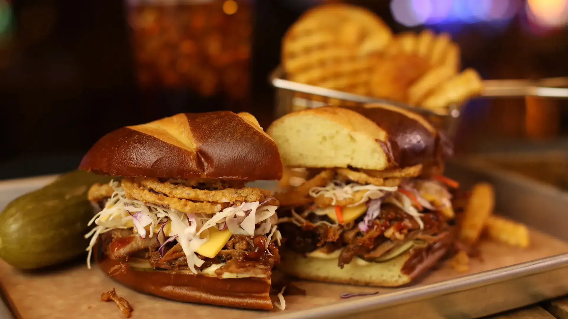 Motley Que pulled pork sandwich with waffle fries and pickle on the side.