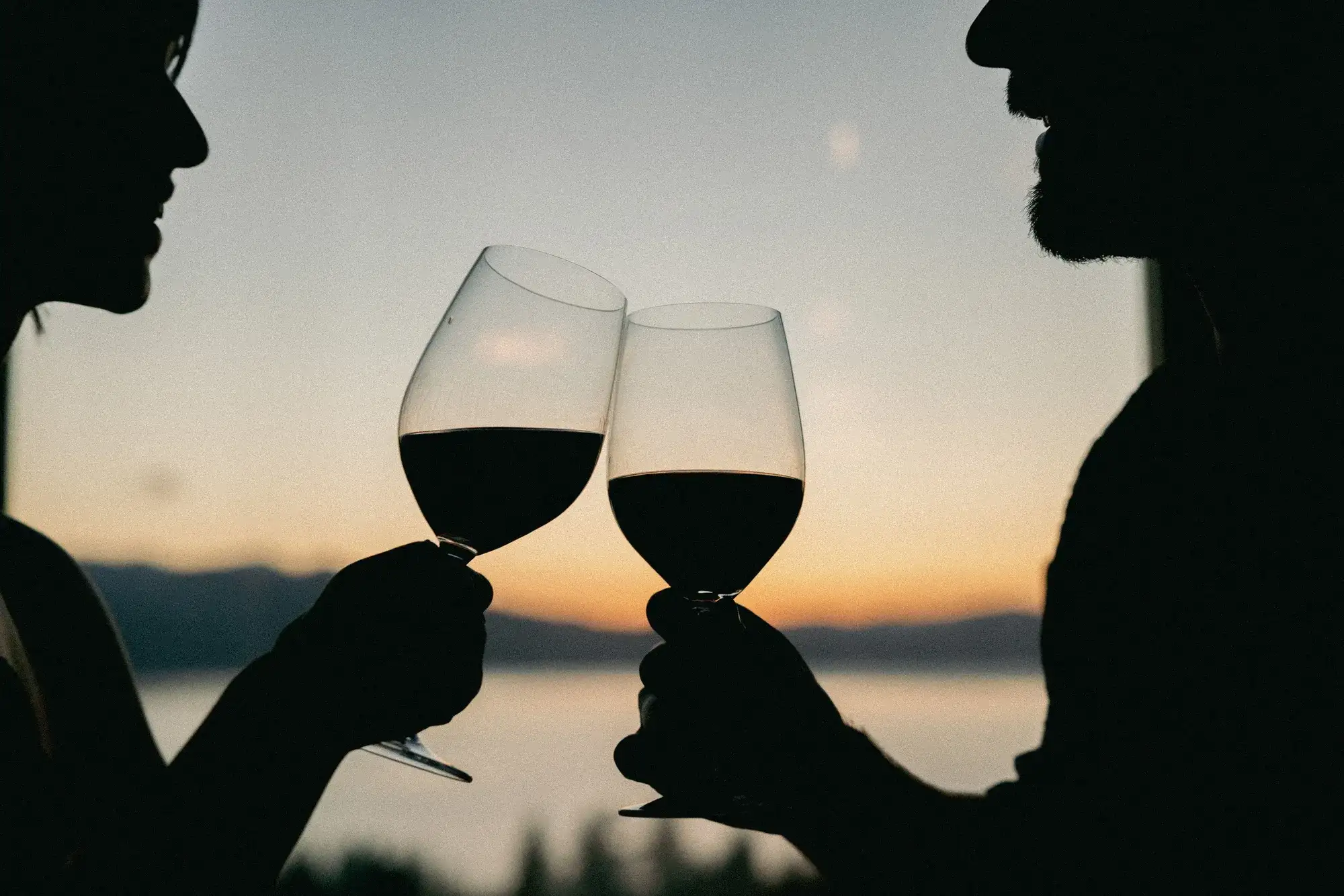 A couple enjoying a glass of wine at sunset over Lake Tahoe at Sage Room Caesars Republic Lake Tahoe.