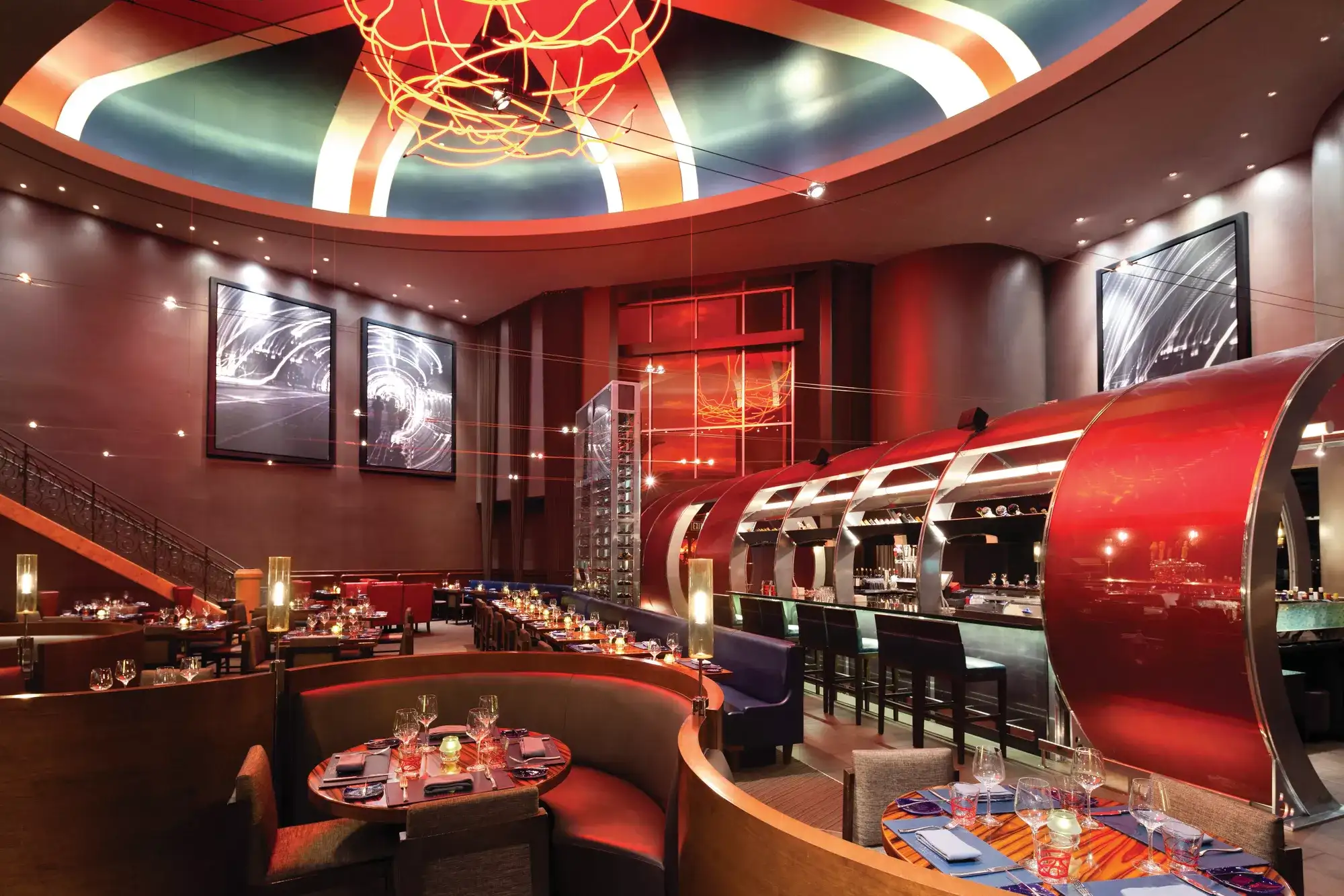 Main dining room at Gordon Ramsay Steak in Paris Las Vegas featuring curved booths, an open bar, and the red Chunnel entrance