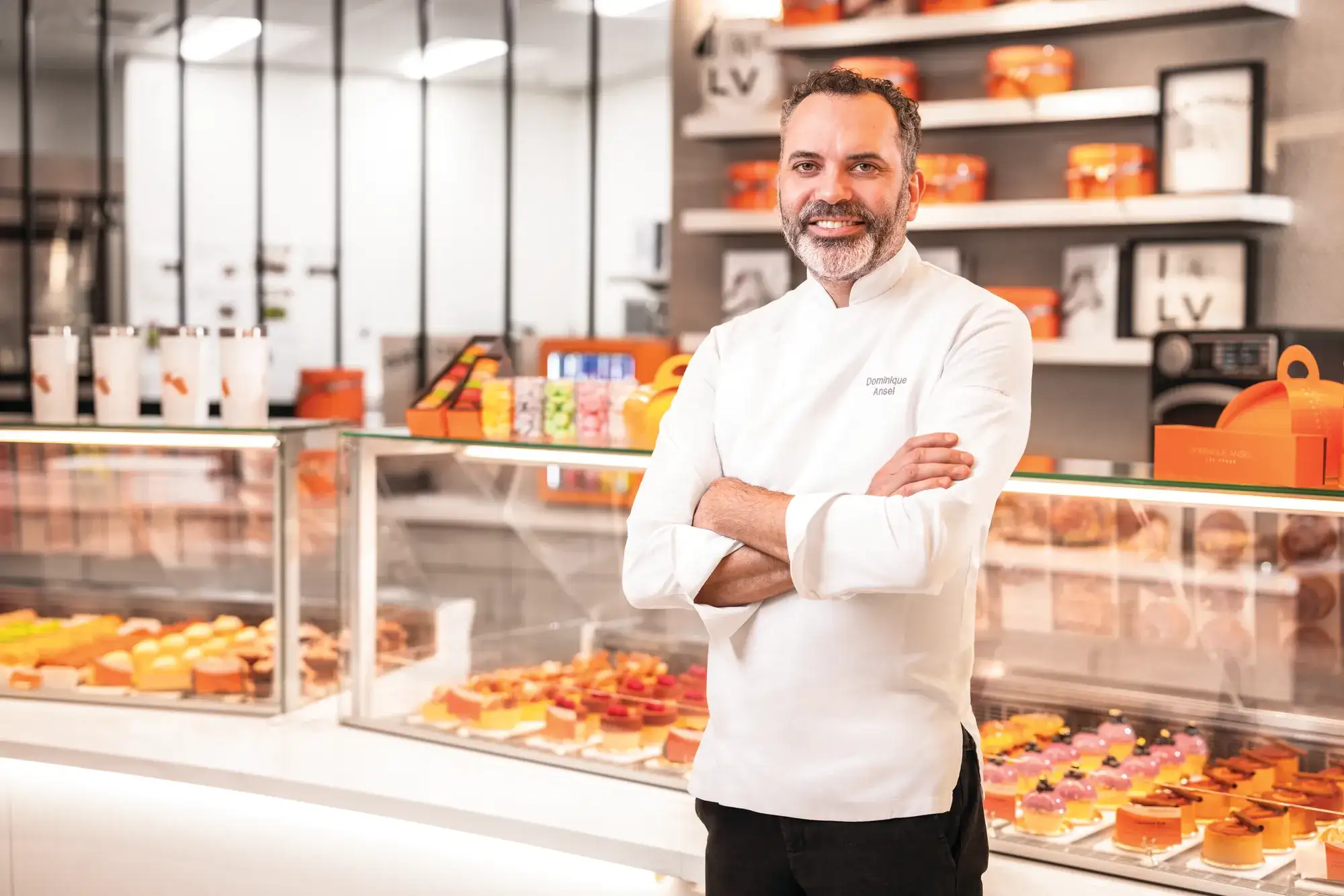 Dominique Ansel posing in front of baked goods