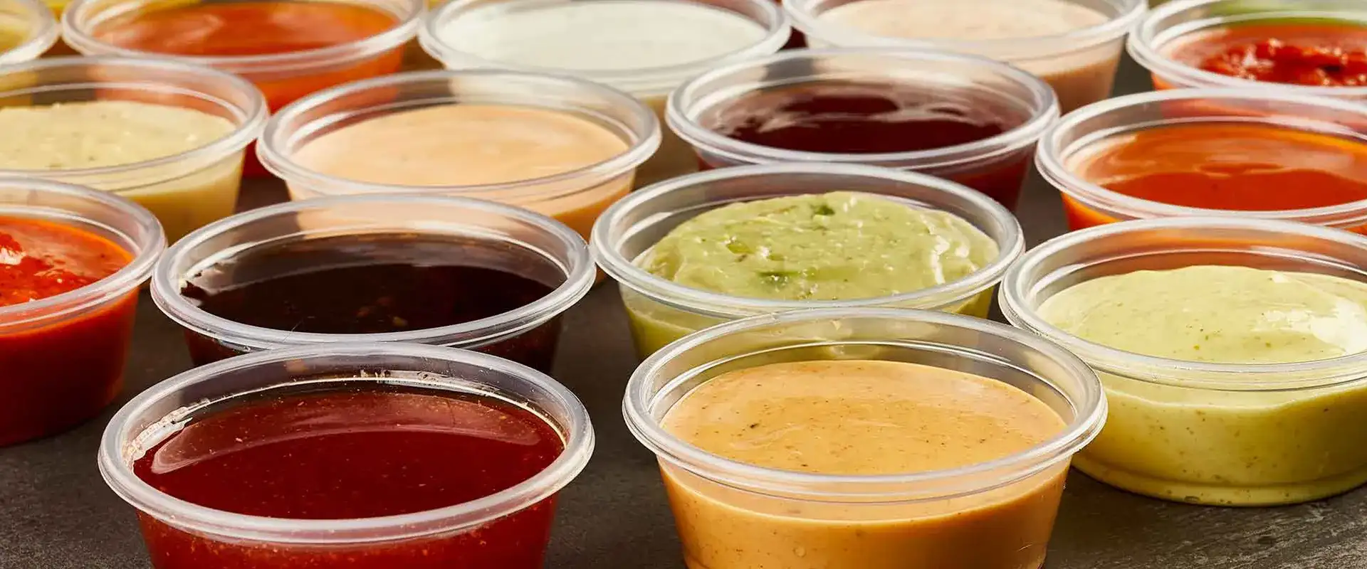 Cups of colorful signature sauces at Chicken Guy!