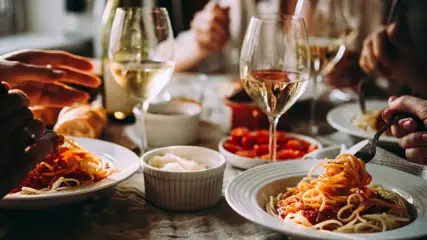 Various plates of food and glasses of wine on a dining table at Oak and Fork restaurant Harrah's Ak-Chin.