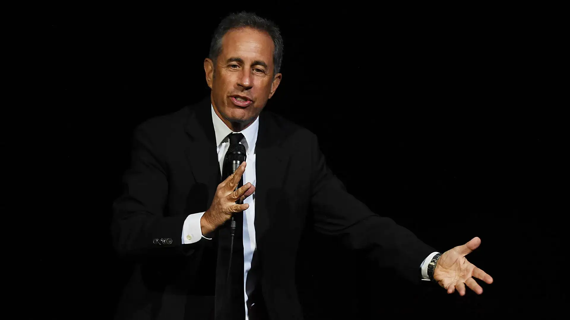 Jerry Seinfeld with a microphone on stage