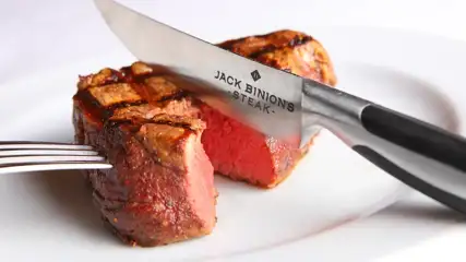 Jack Binion's branded steak knife cutting into a medium rare steak.