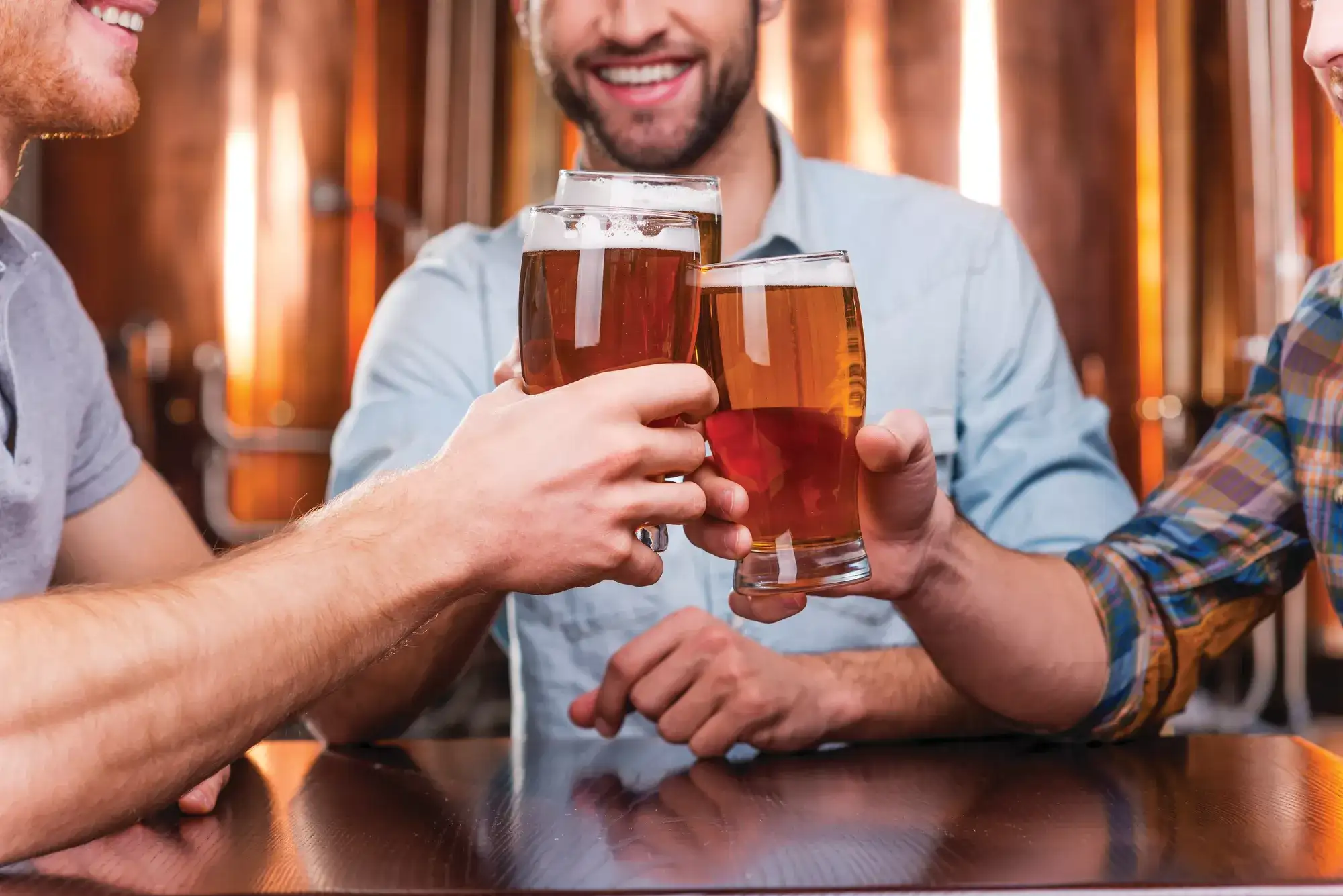 Three people toasting their drinks.