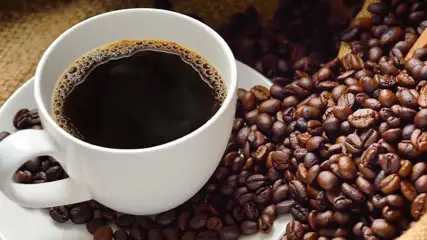 Cup of coffee with beans on the saucer.