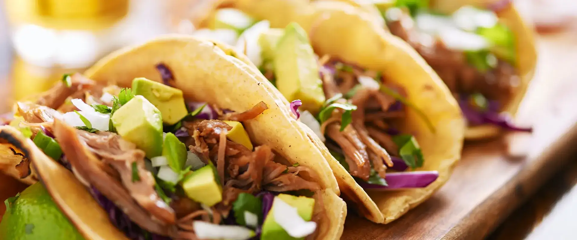 Three street tacos on a serving board
