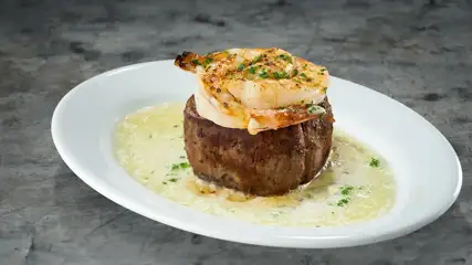 Filet mignon with shrimp plated on a dish.