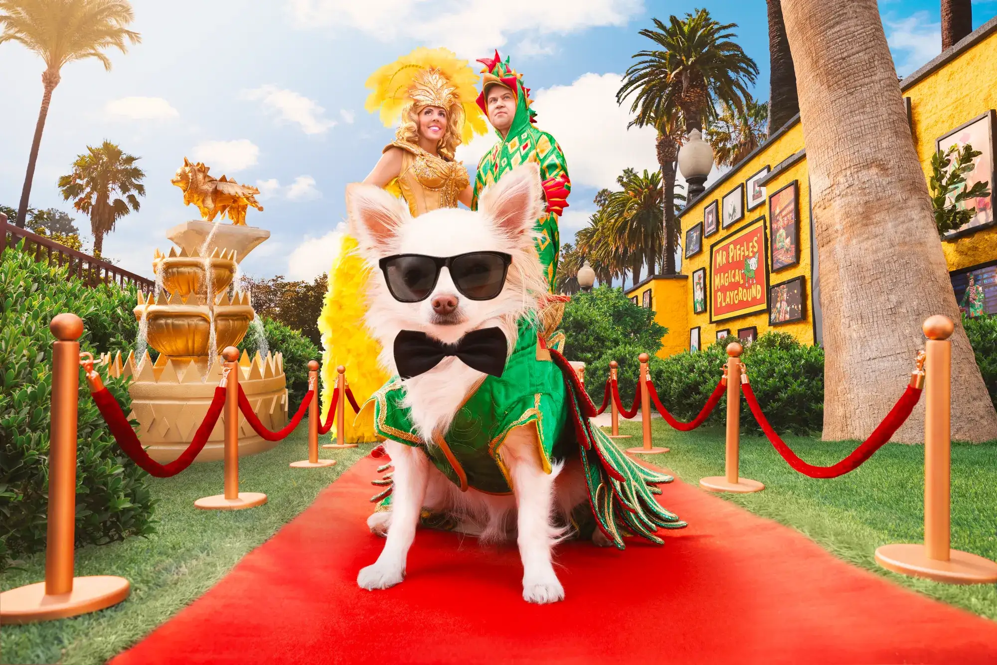 Mr. Piffles the Chihuahua in sunglasses and a green cape poses on a red carpet at the Piff the Magic Dragon show at Flamingo Las Vegas, with Jade Simone and Piff the Magic Dragon