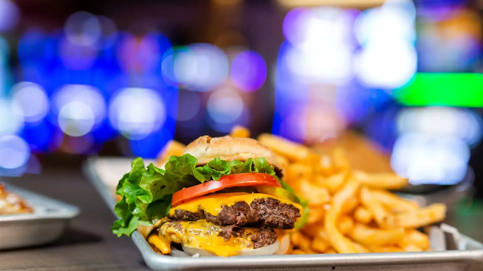 Cheeseburger and fries on a silver platter.