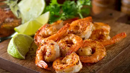 Seasoned shrimp with lime wedges.