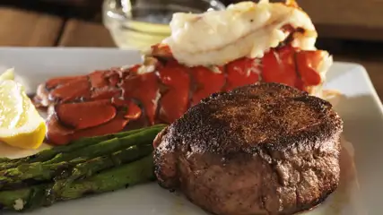 Steak and lobster with a side of asparagus.