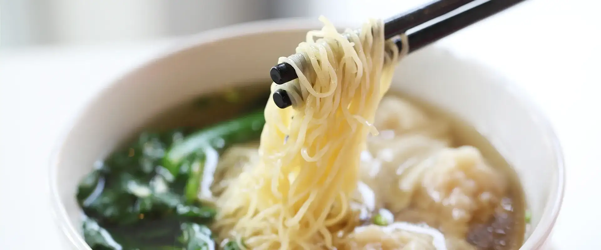 Wonton soup with chopsticks.