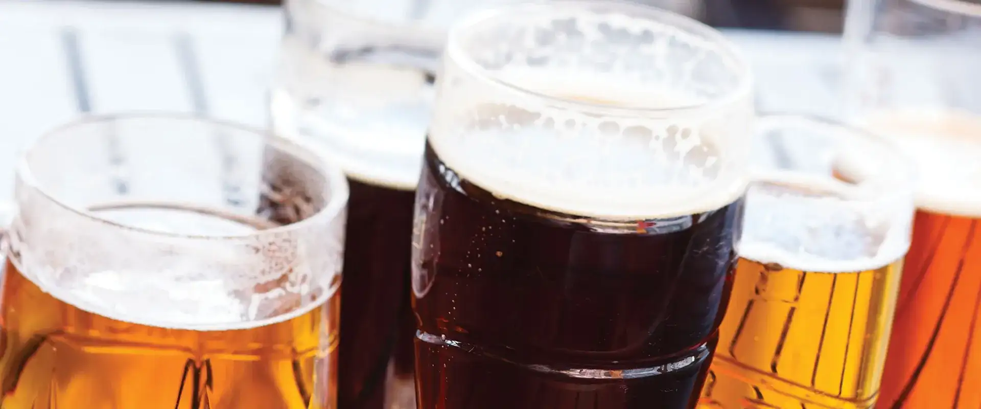 A variety of beers in pint glasses.