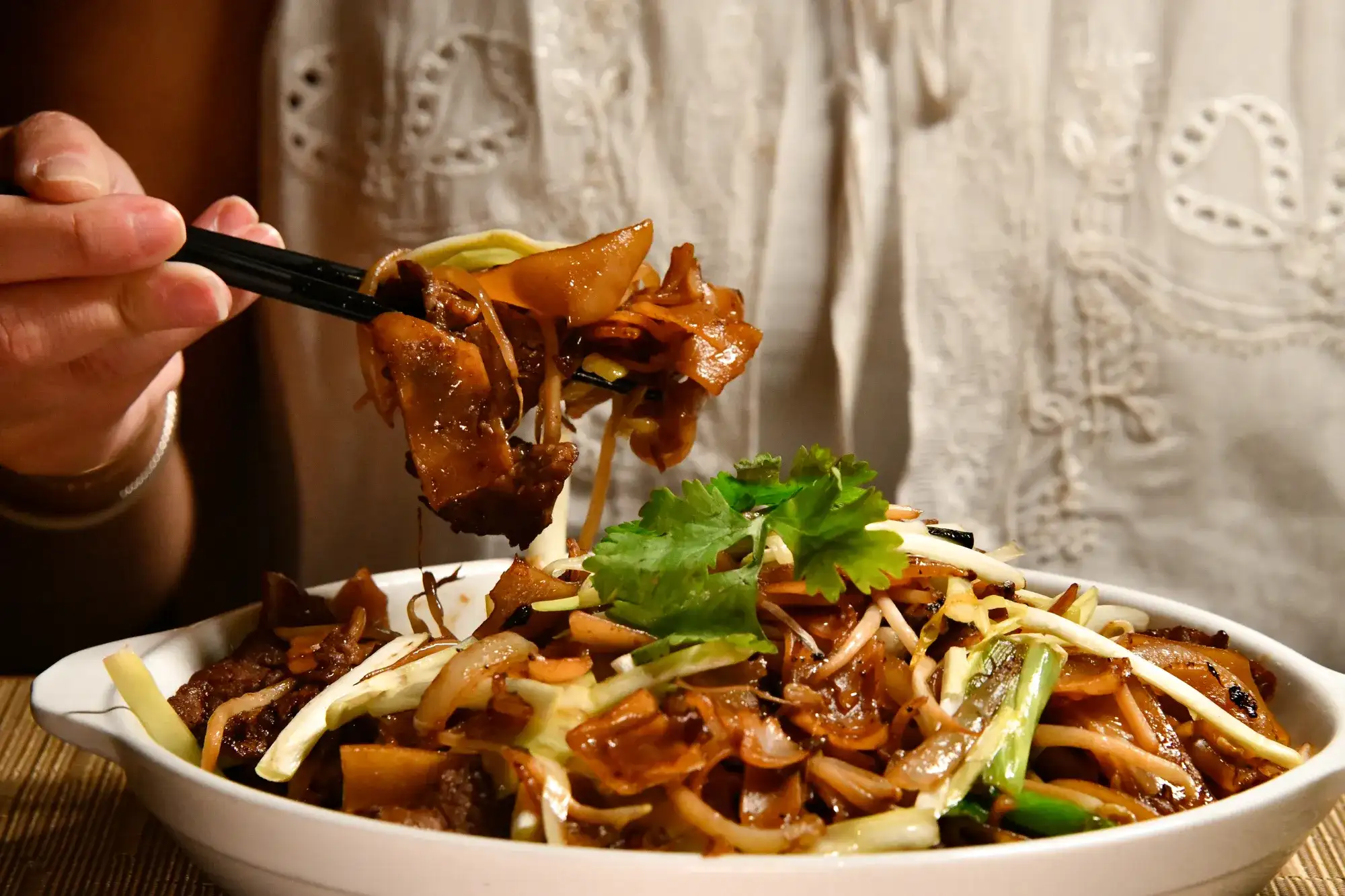 Woman enjoying a bowl of noodles.