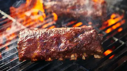 Baby back ribs on a BBQ.