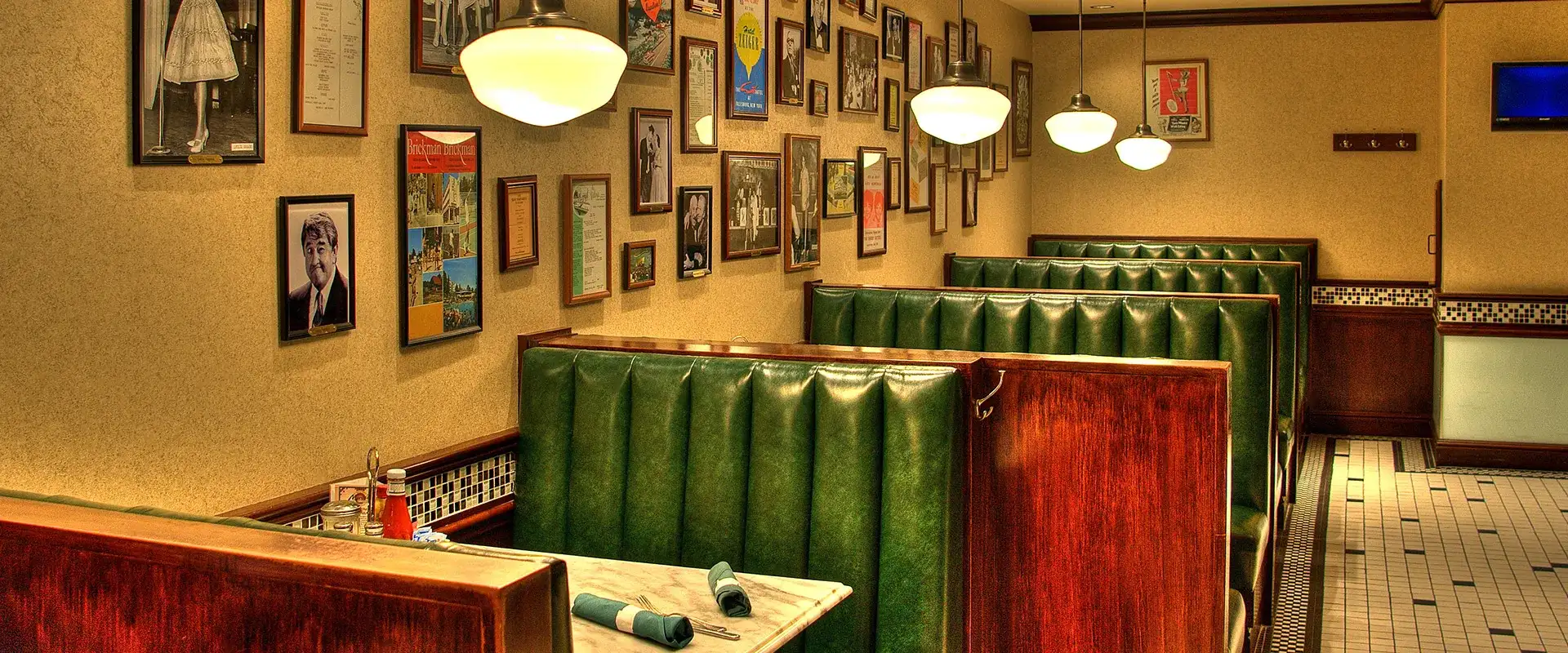 Myron's interior with booths, pendant lighting, and photos on the wall.