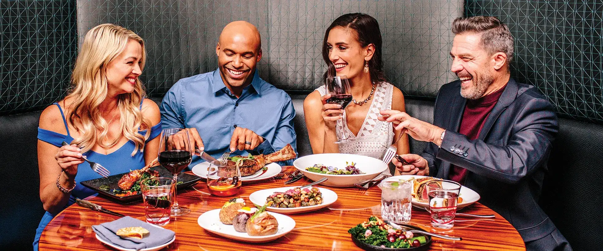 Two couples having dinner together.