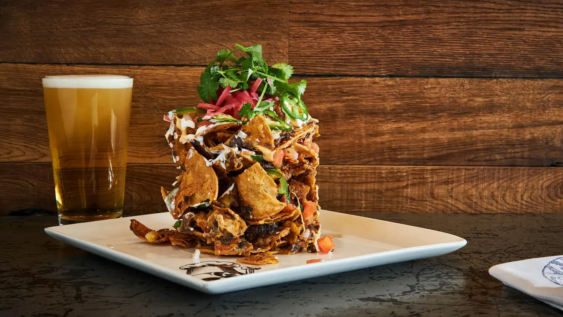 Trash can nachos and a glass of beer