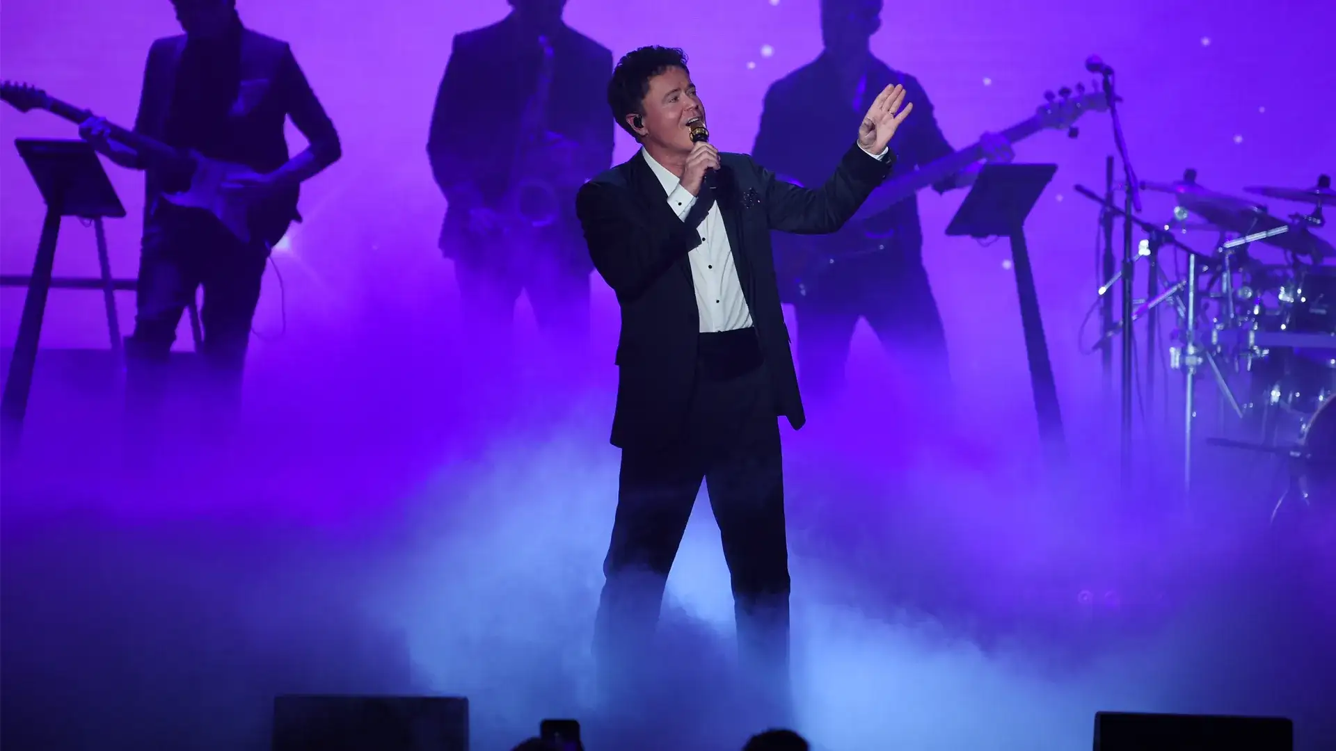 Donny Osmond Performong on stage with backed by live band
