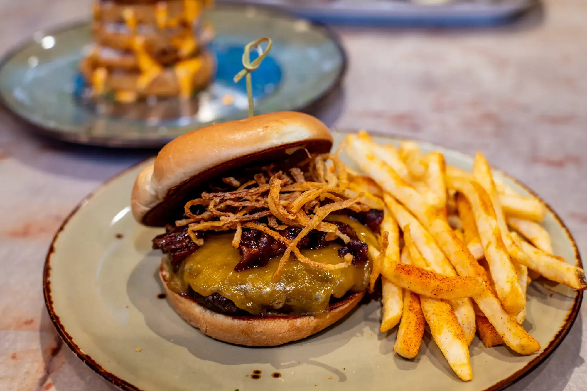 Bacon Jam Burger with Onion Ring Tower and Potato Skins in the background