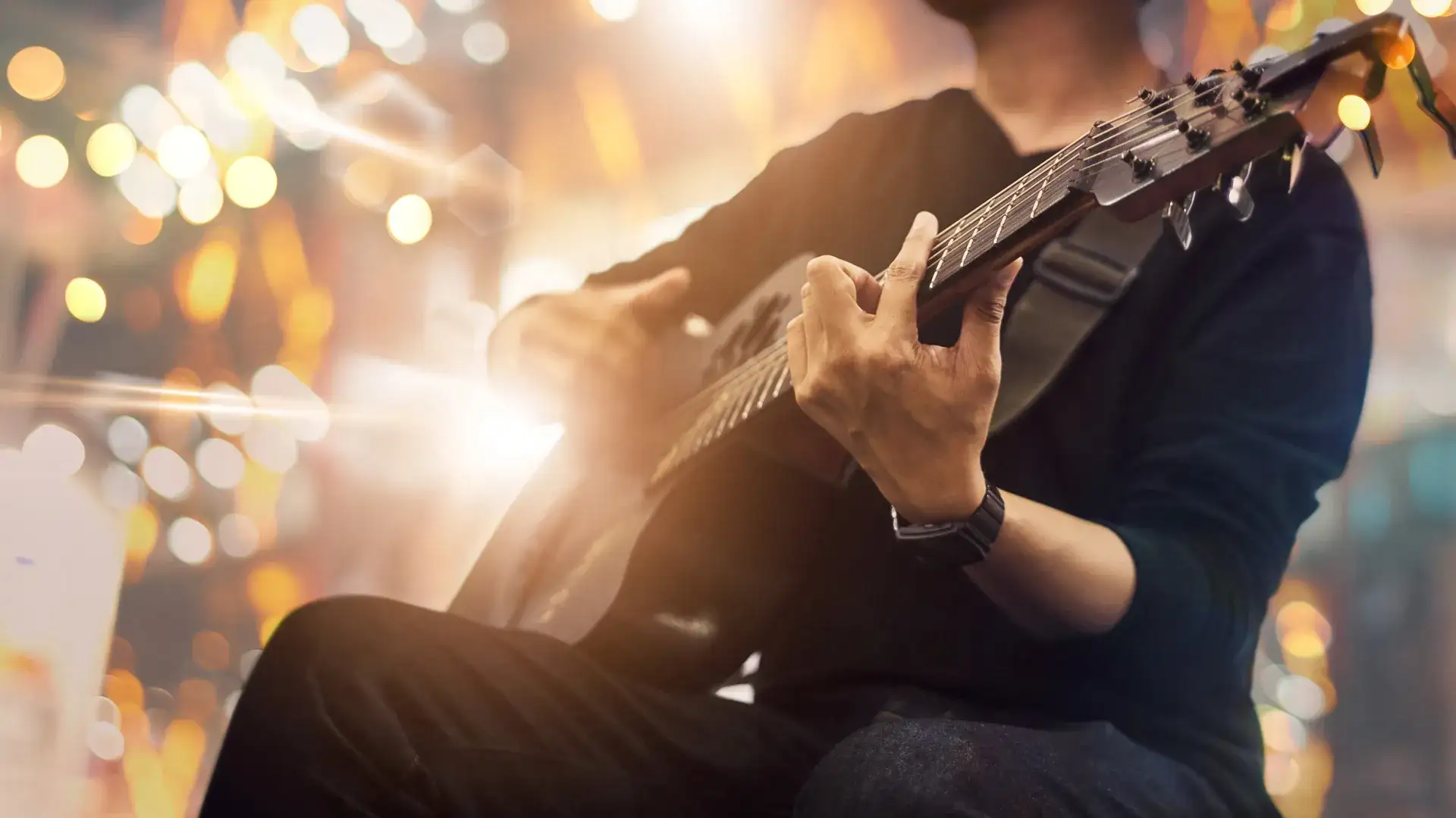 Man sitting playing a guitar