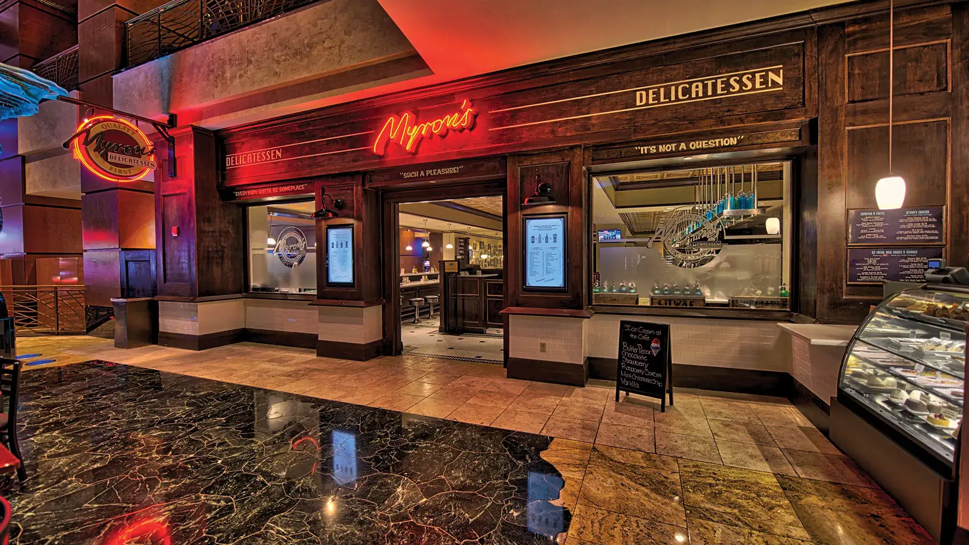 Myron's Deli entrance with red neon sign.