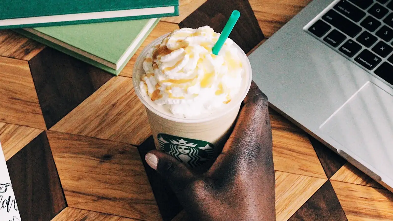 Starbucks beverage with whip cream and straw.