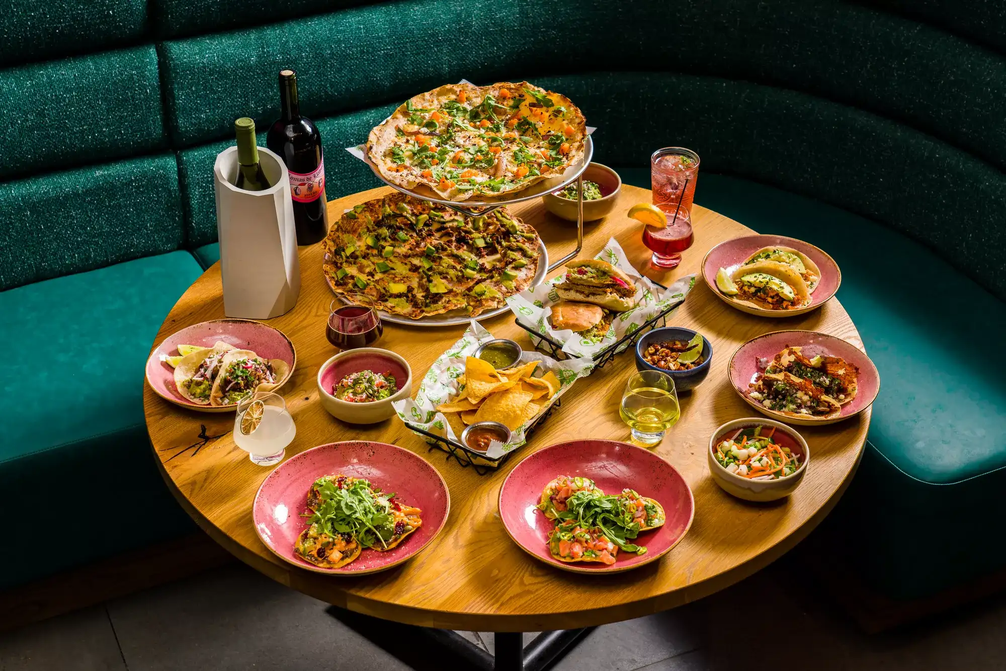 Table full of various nachos, tacos, chips & salsa and an assortment of alcoholic beverages from Tortazo at Harrah's Joliet.