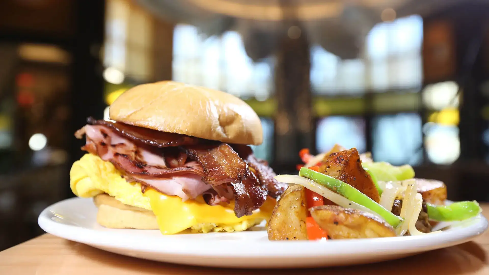 Breakfast sandwich with side of potatoes.
