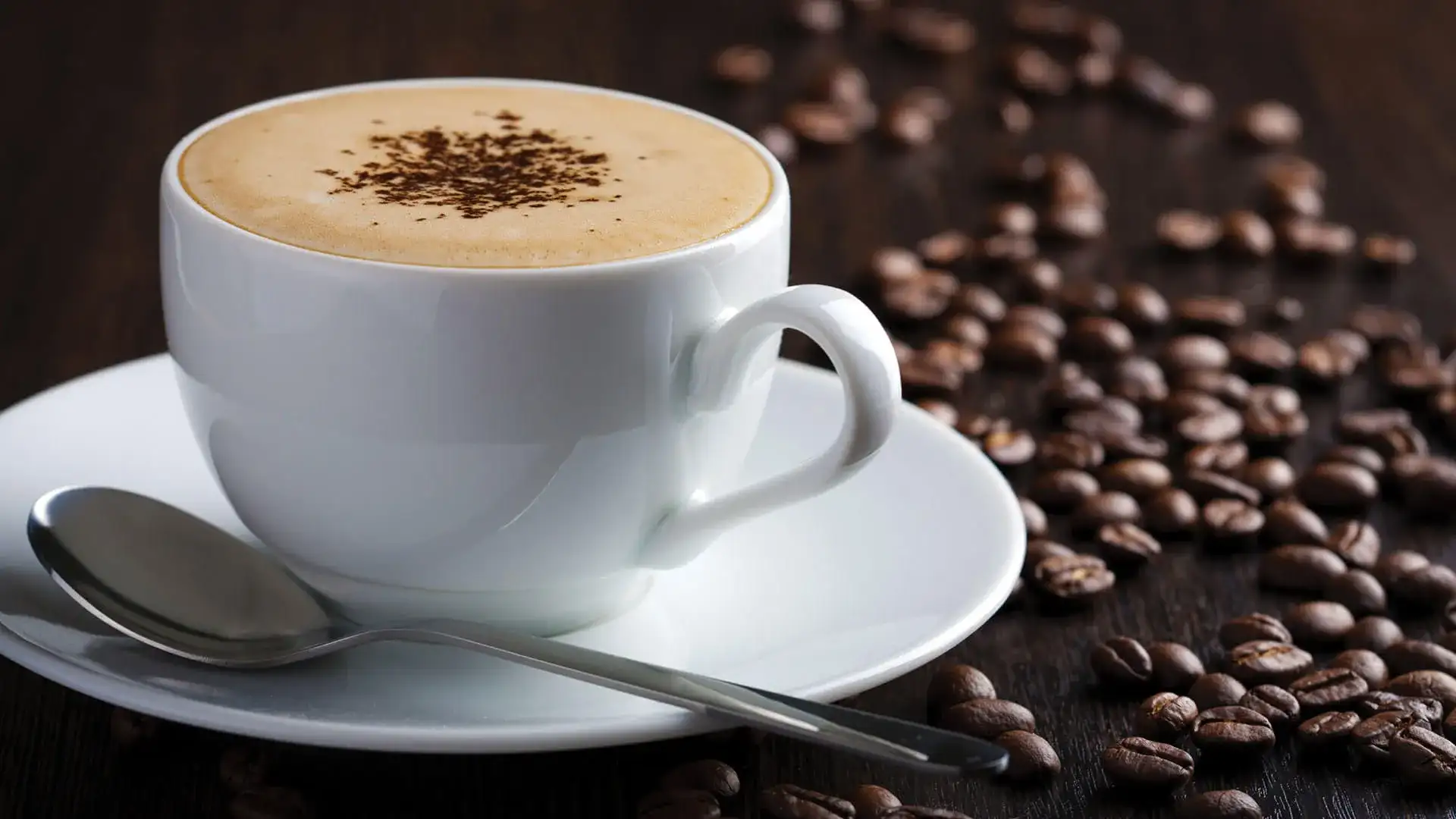 Cup of coffee next to coffee beans