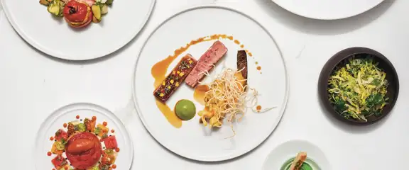 Multiple plates against a white background at Guy Savoy in Caesars Palace Las Vegas.