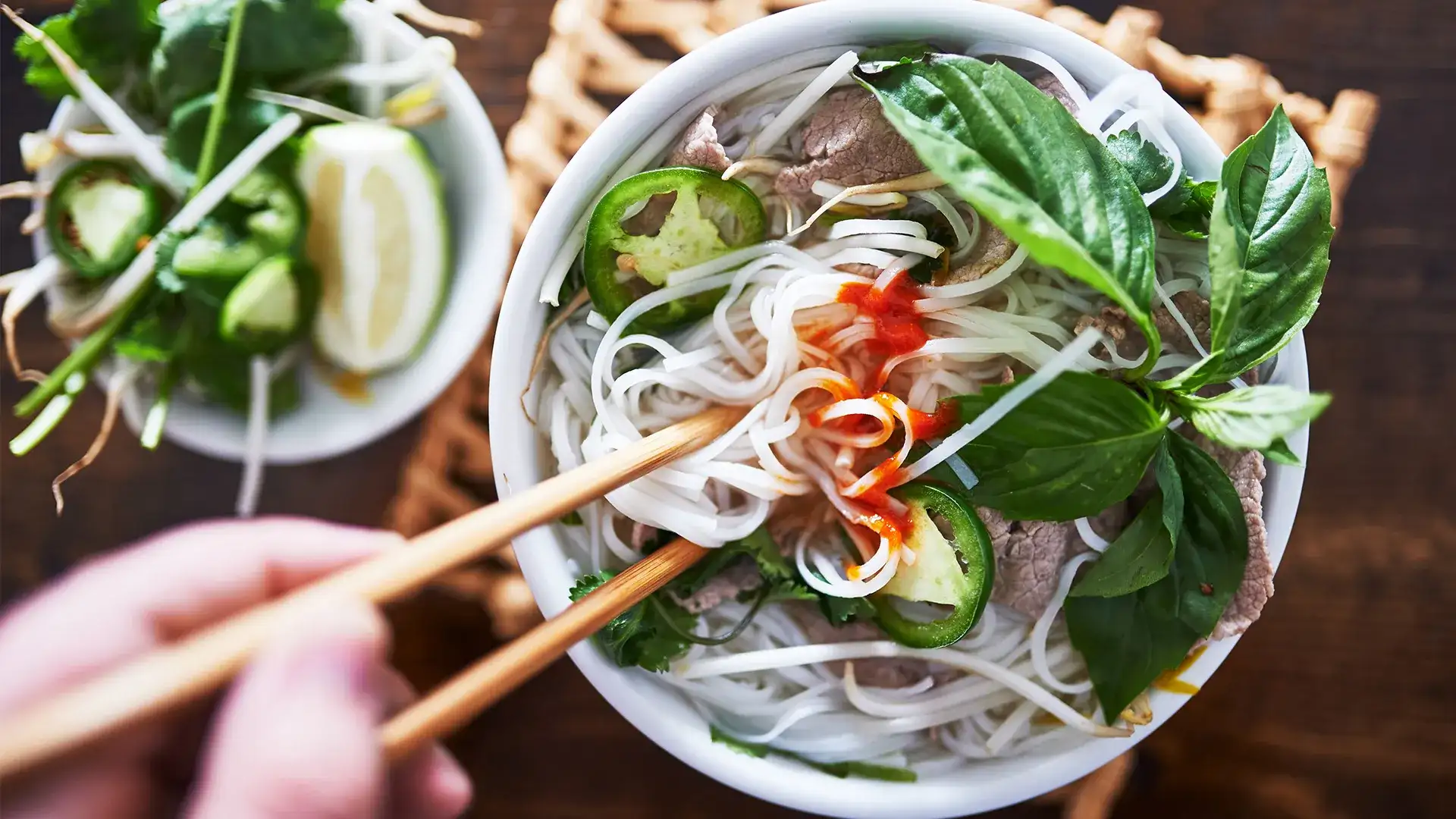 Bowl of noodles with fresh basil and jalapeno.