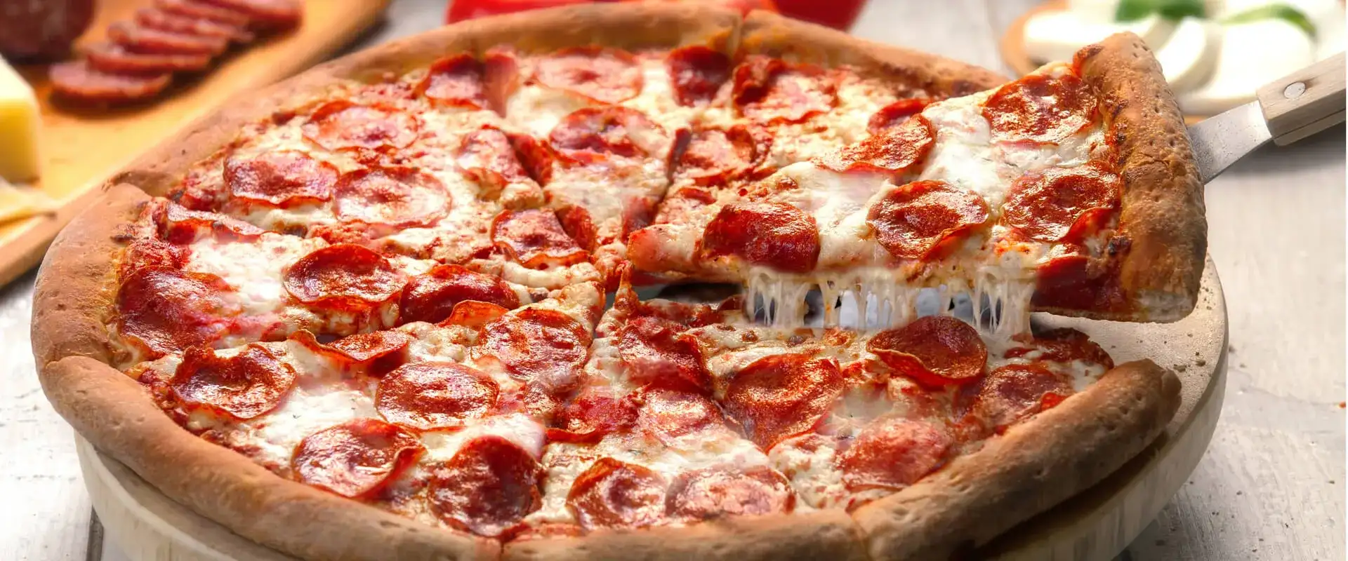 Peperoni pizza on a wood slab