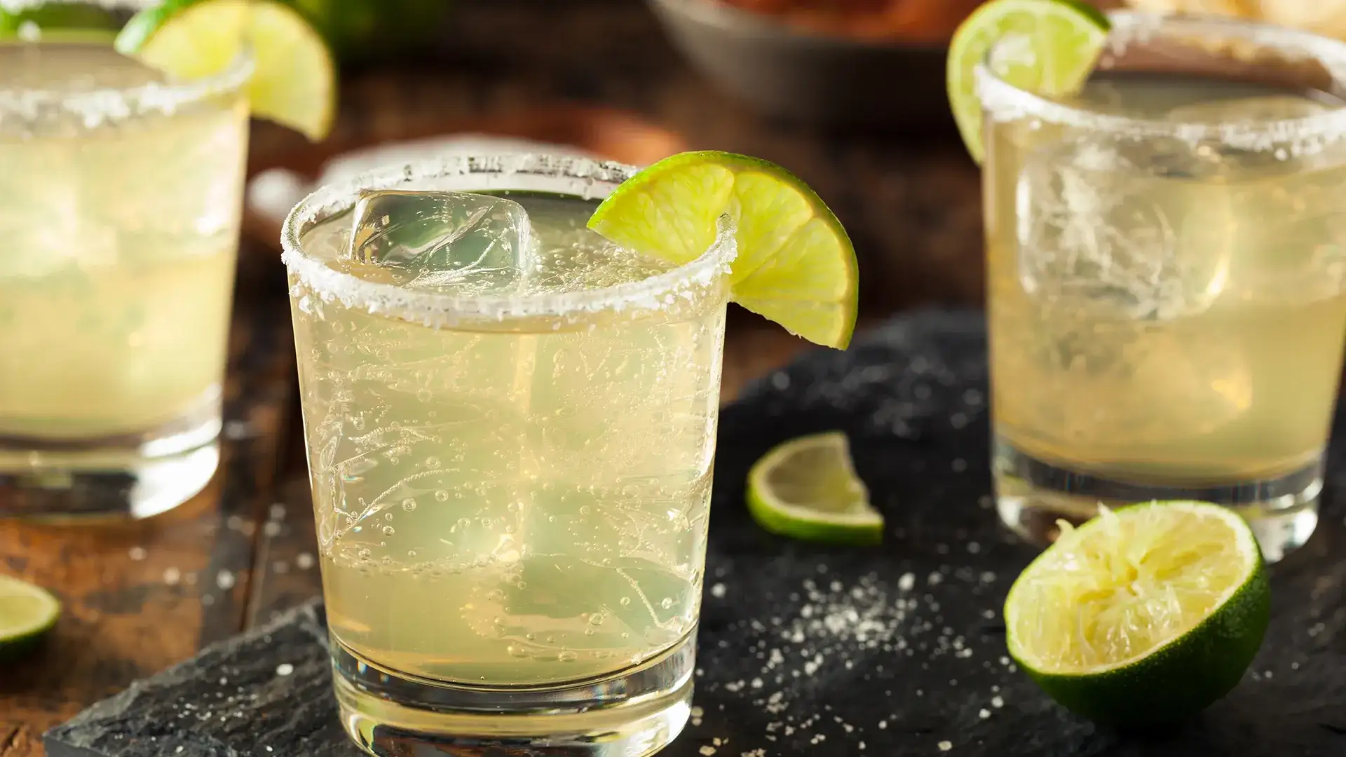 Margaritas with salt rim and lime garnish.