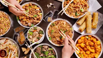Table filled with a variety of takeout food.