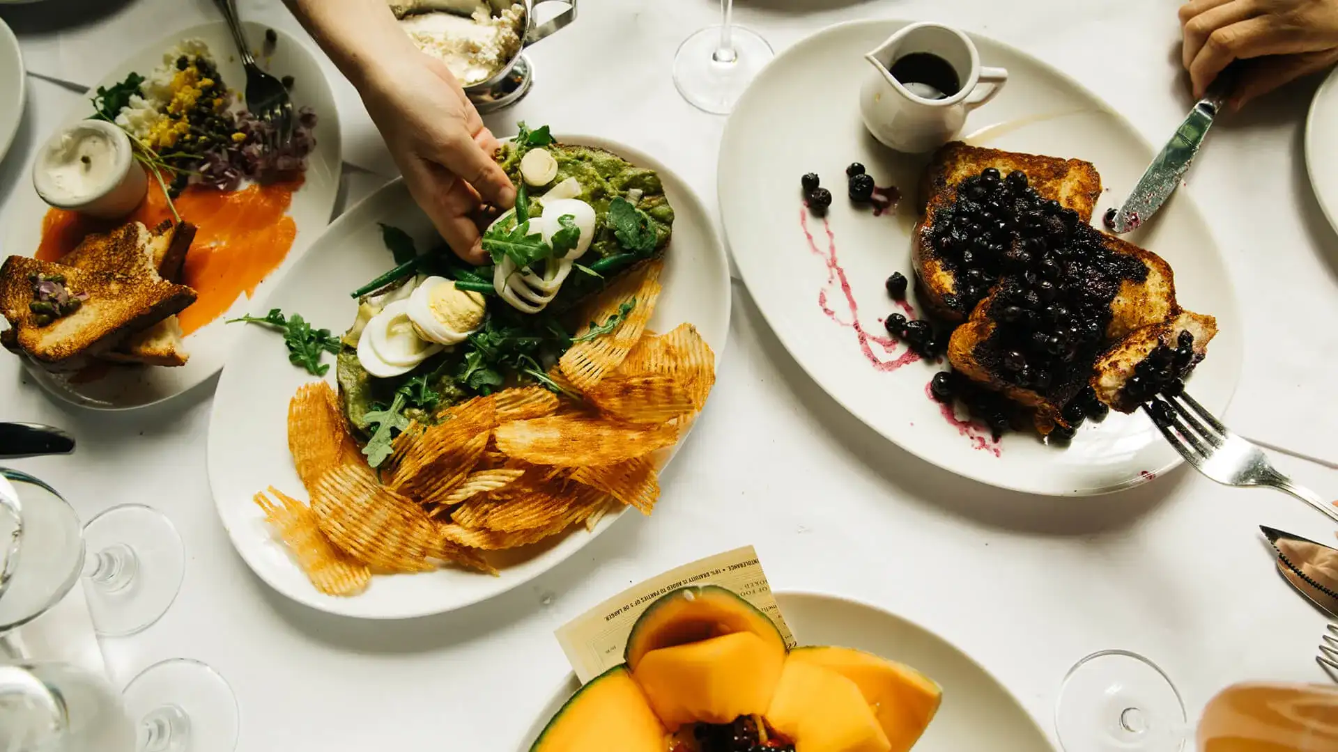 several plates of French food: salad and chips, French toast, smoked salmon