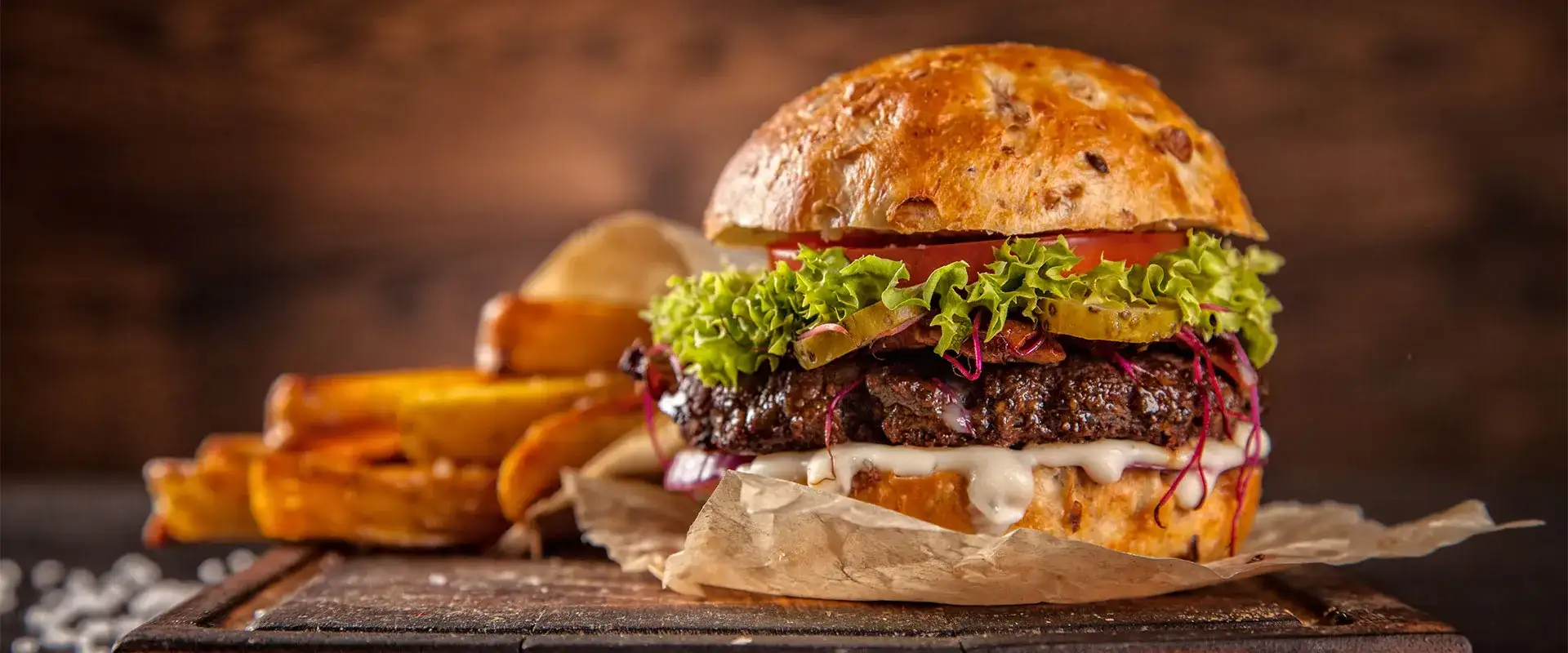 Hamburger plated next to fries