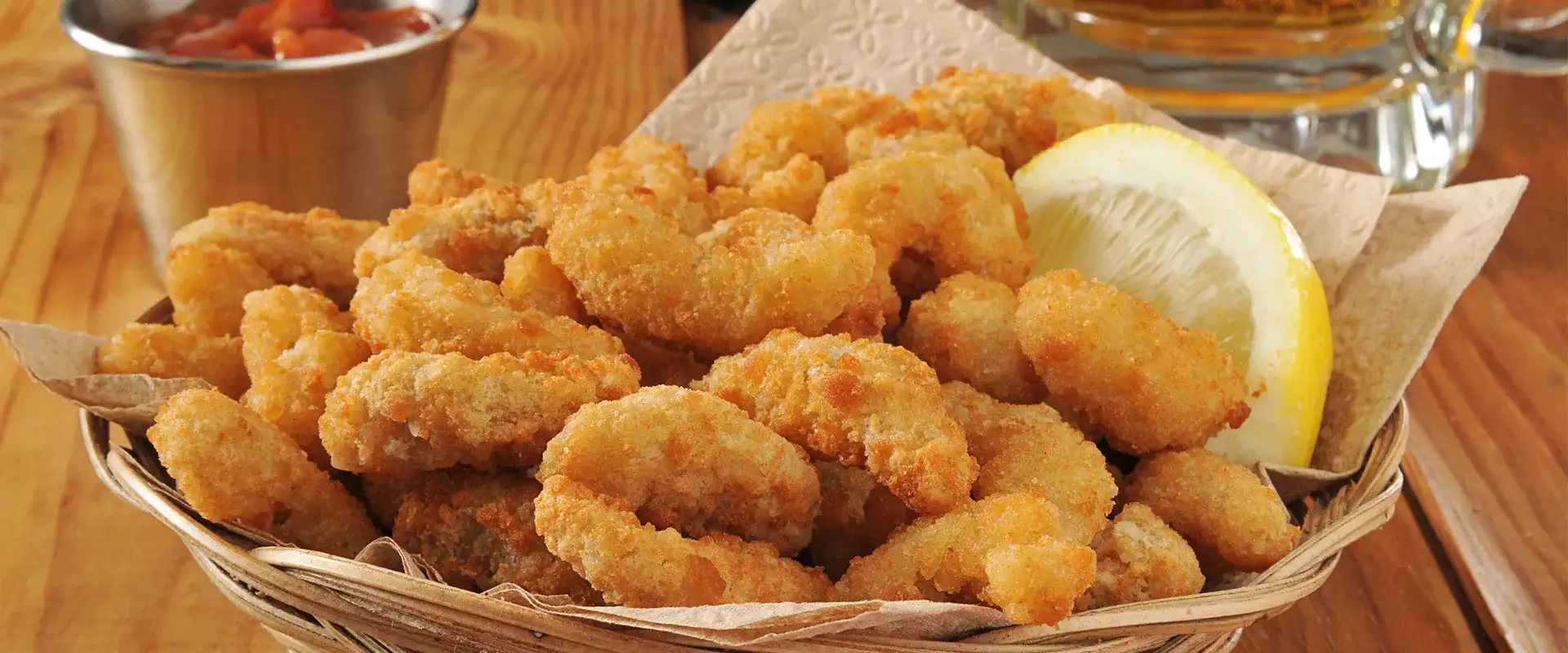 fried shrimp in a basket with cocktail sauce