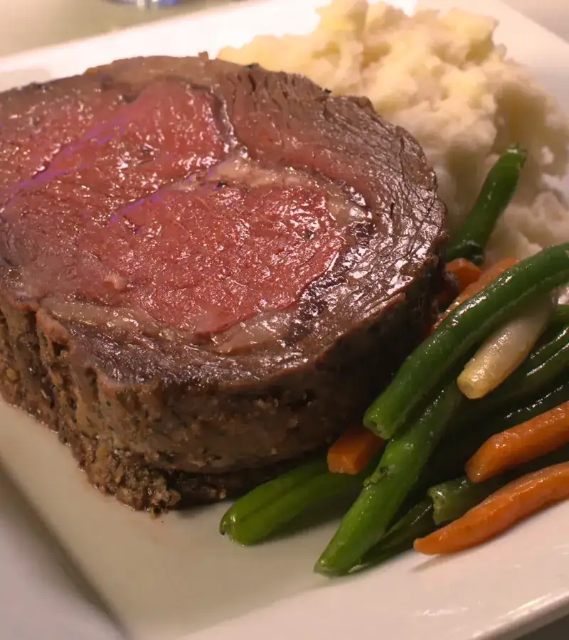 Prime rib with side of green beans and mashed potatoes.