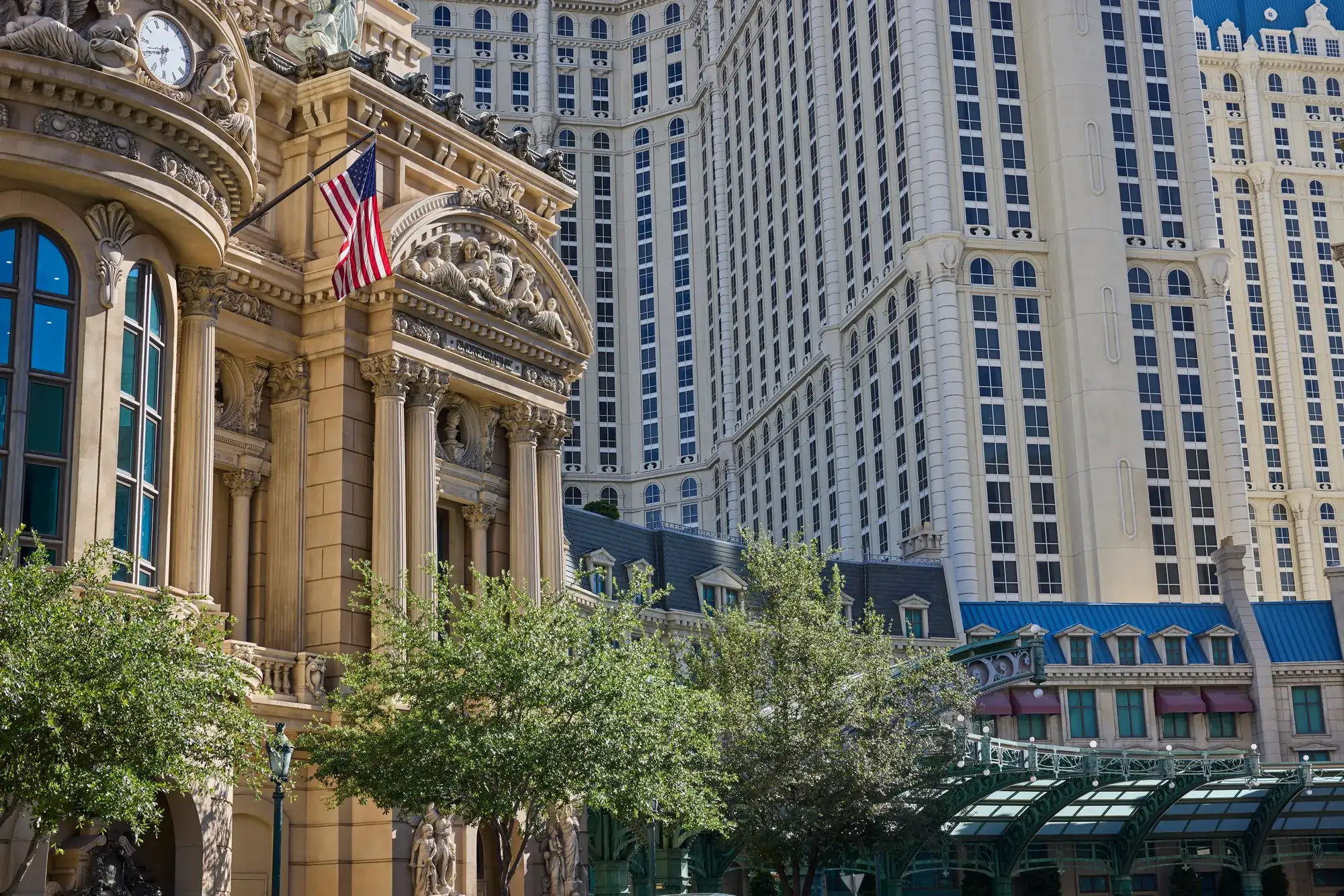 Paris Las Vegas hotel exterior with French-inspired architecture, tall resort towers, trees, and glass canopy