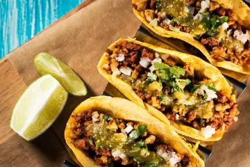 Tacos served next to limes