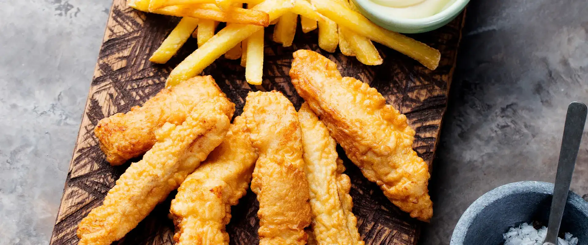 fried catfish, fries, and aioli on a platter.