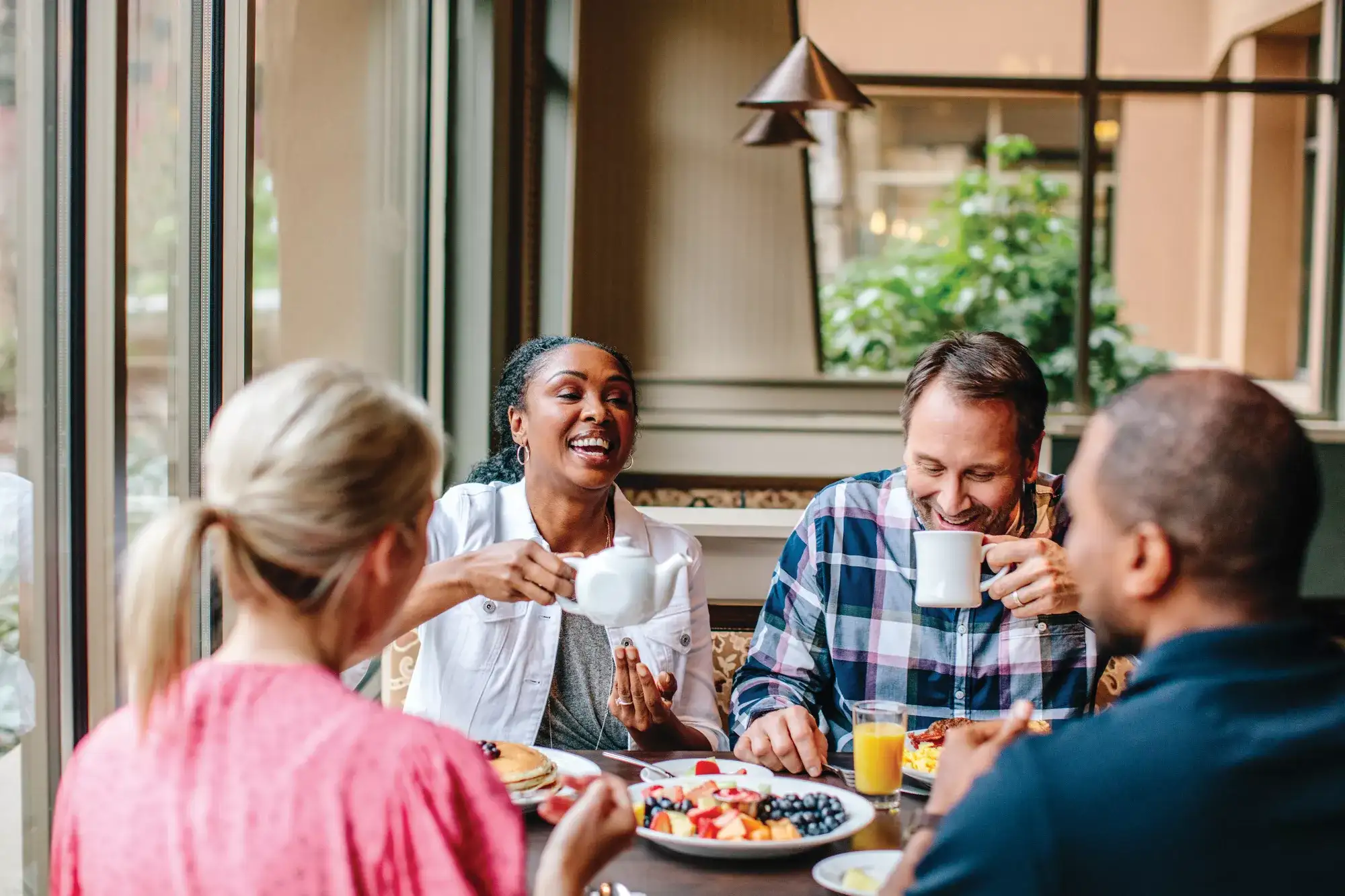Group of people dining next to a window