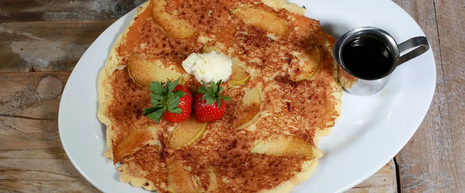 Hash House a Go Go Apple Cinnamon Flapjack with strawberries, butter and syrup