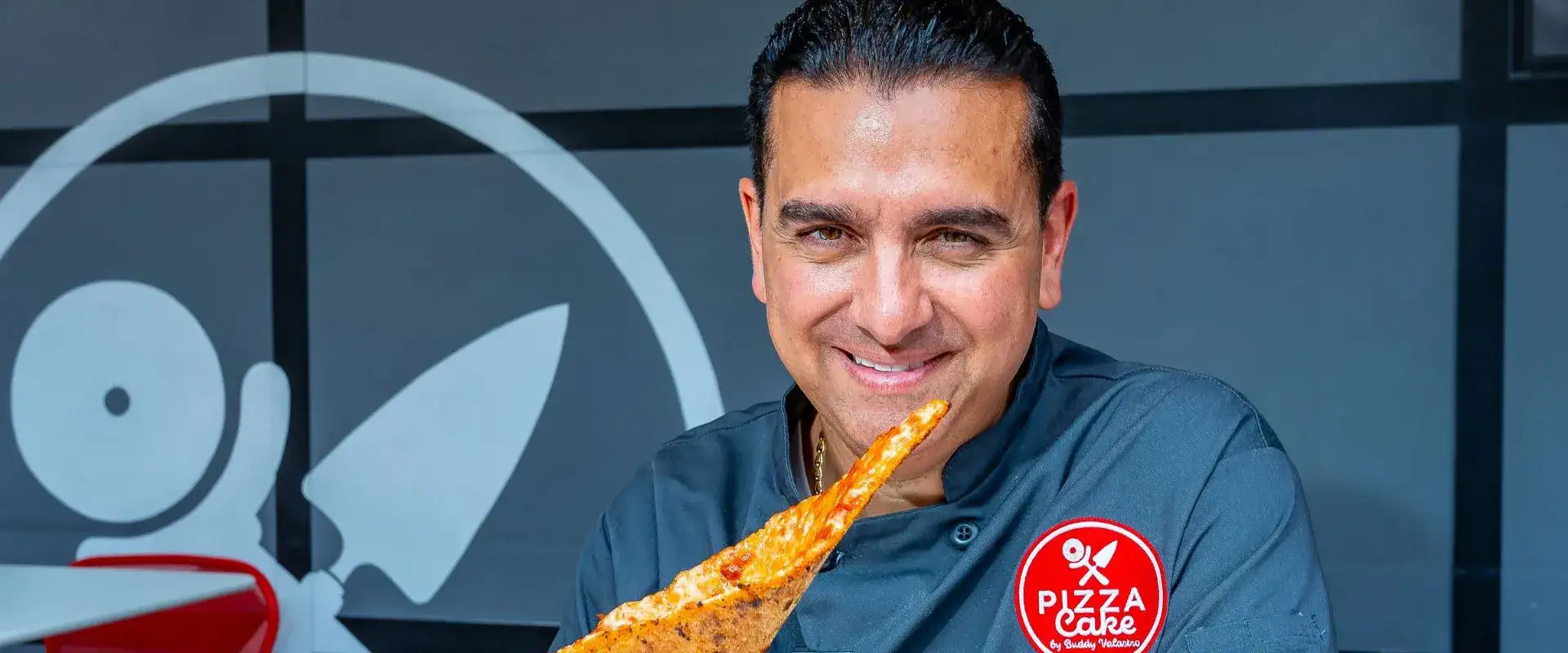 Buddy Valastro holding a pizza slice