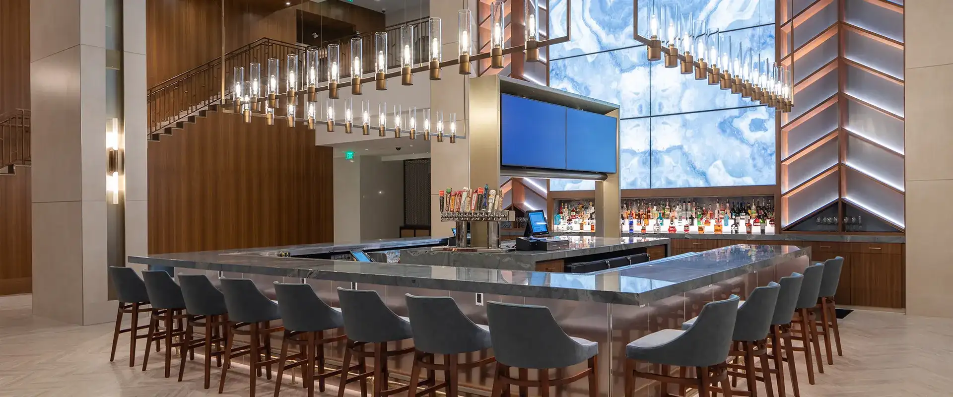 Rectangular bar, ornate light fixtures, and bar seating.