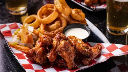 Chicken wings, onion rings, and ranch on a plate
